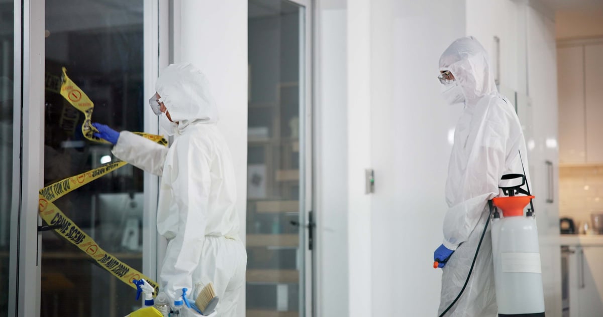 Worker in PPE suit and crime scene with cleaning